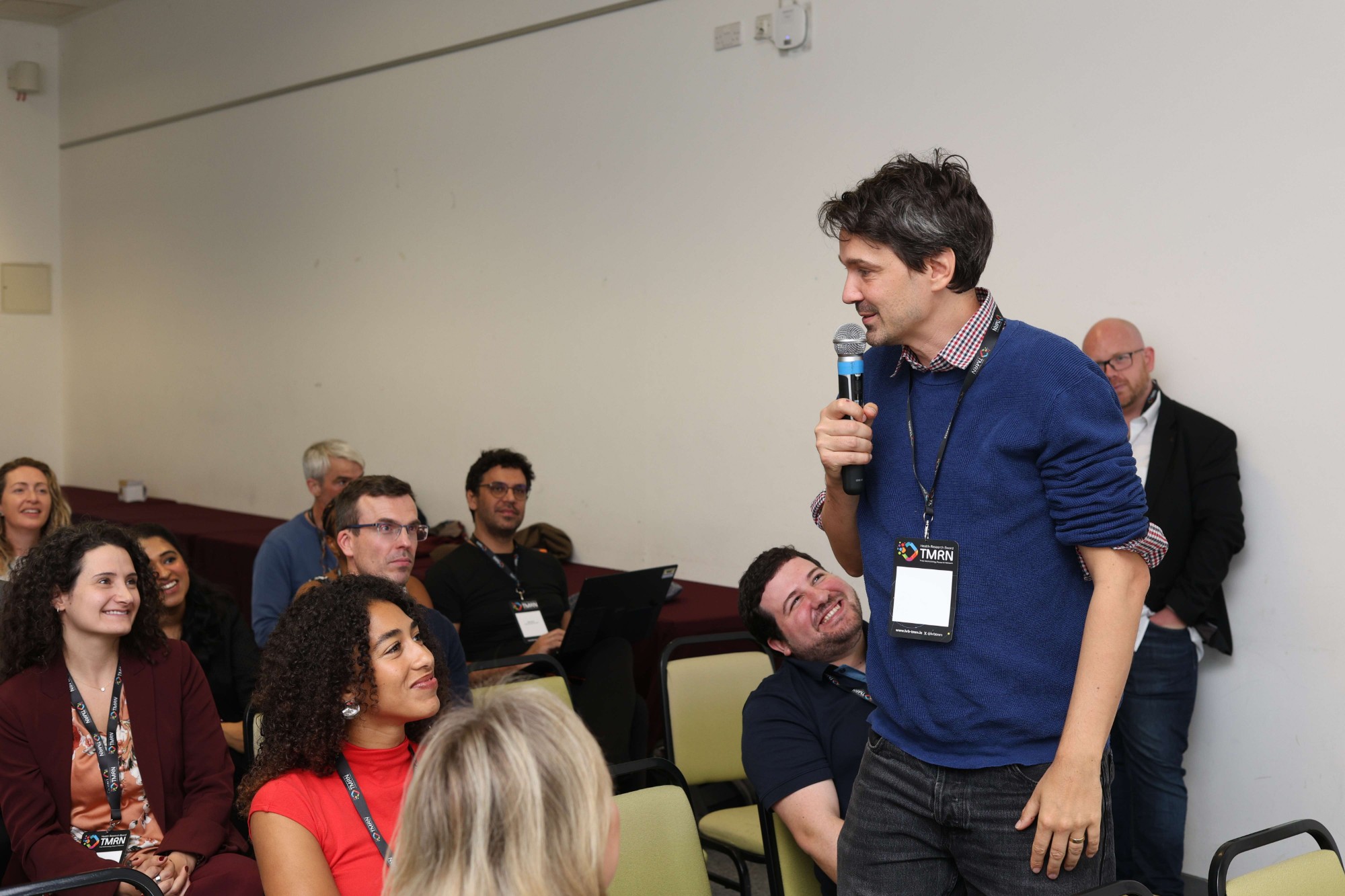 A participant speaking into a microphone during a group discussion