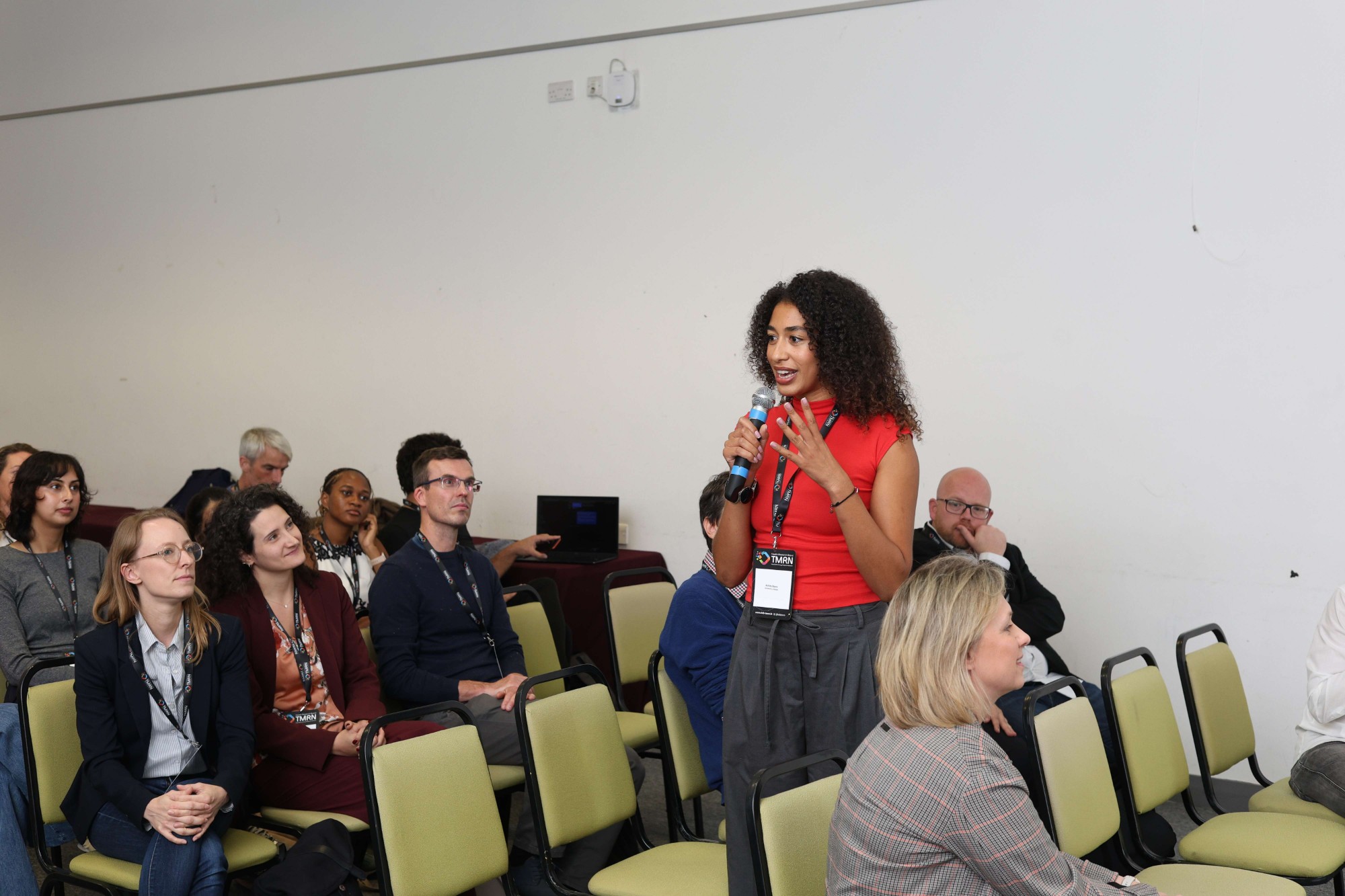 A doctoral candidate speaking into a microphone during a group discussion